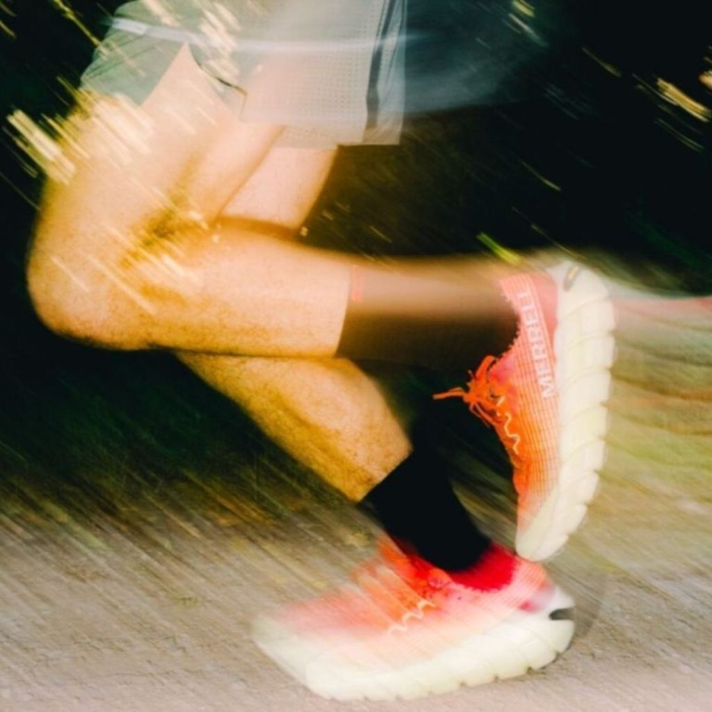A man's legs running in Merrell shoes.