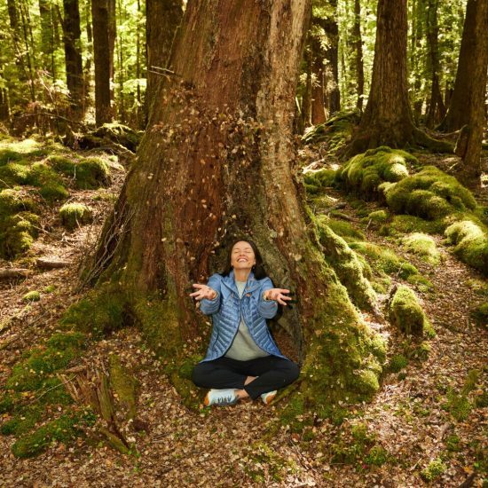 woman smiling sitting by tree