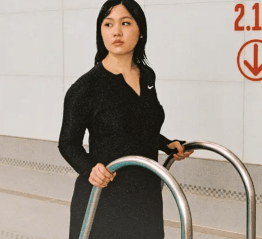 woman in nike swim swimwear walking up swimming pool stairs