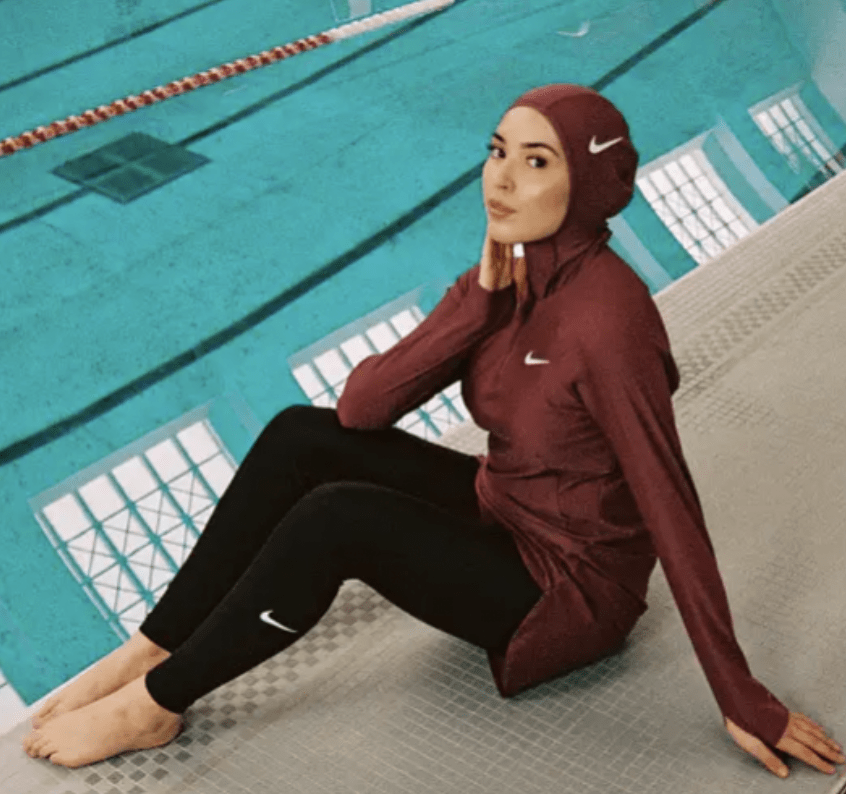 woman posing by swimming pool wearing nike swim swimwear