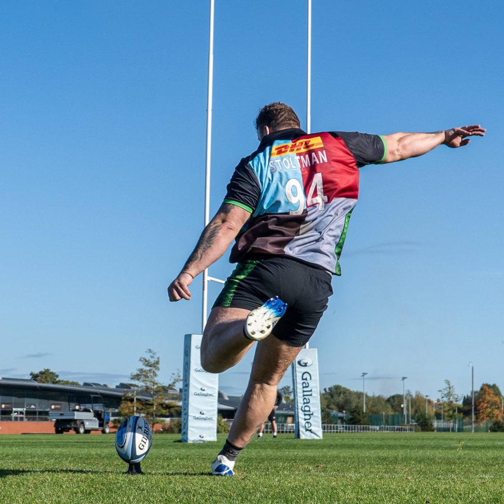 a stoltman brother kicking a rugby ball into the goal