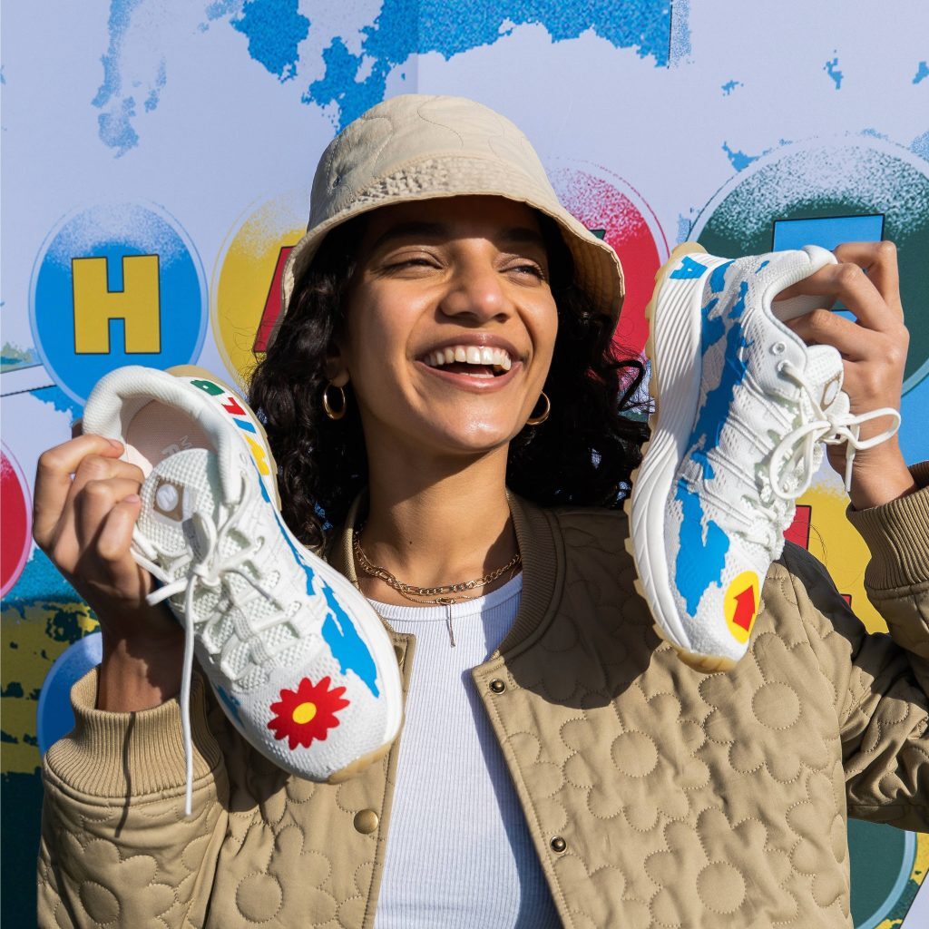 female model holding up merrell know your code trainers