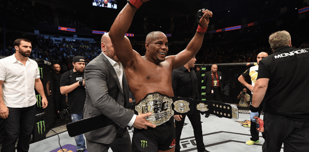 ufc fighter celebrates victory with belt around waist