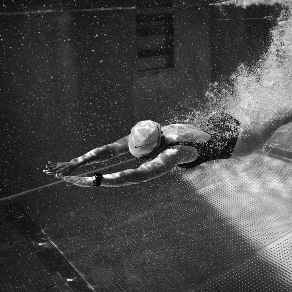 model swimming underwater in nike swim swimsuit