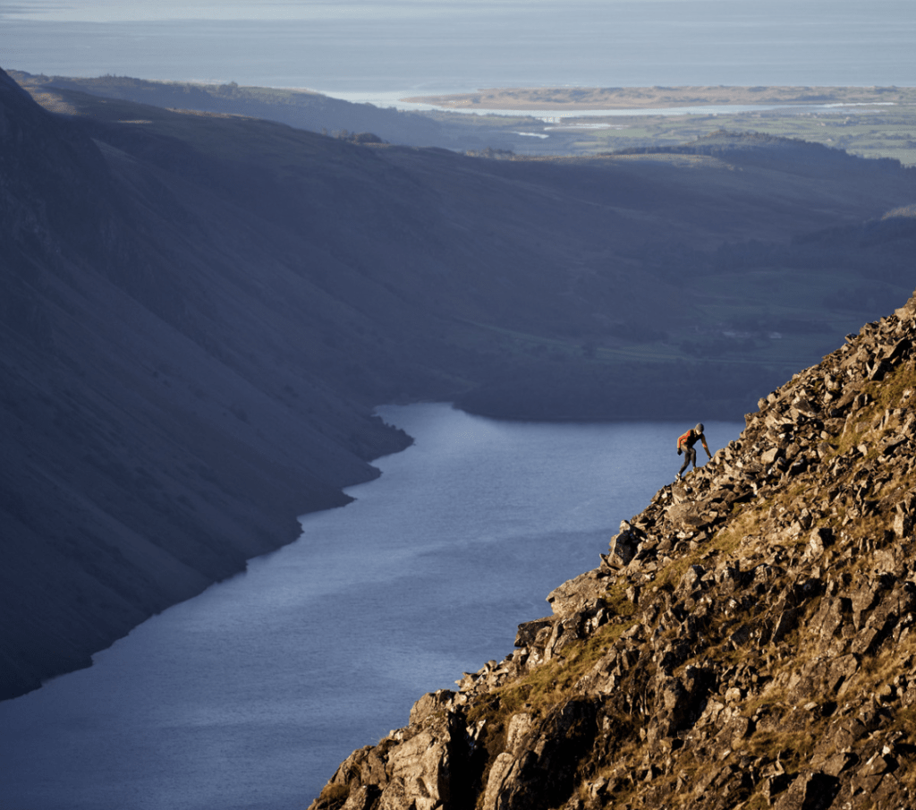 man running up hill in merrell trainers