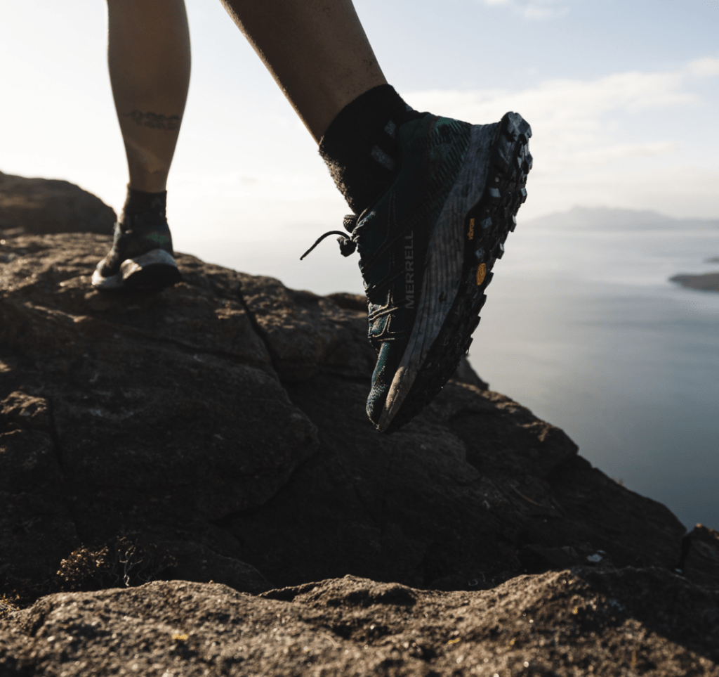close up of man wearing merrell trainers walking up hill