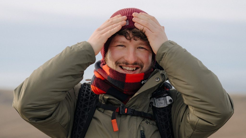 man with hands on head smiling