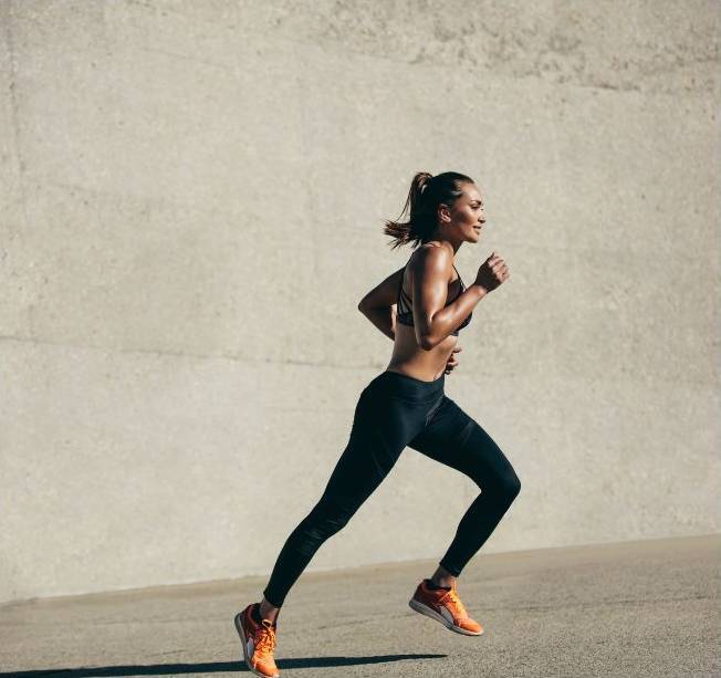 female model running in orange nurvv trainers