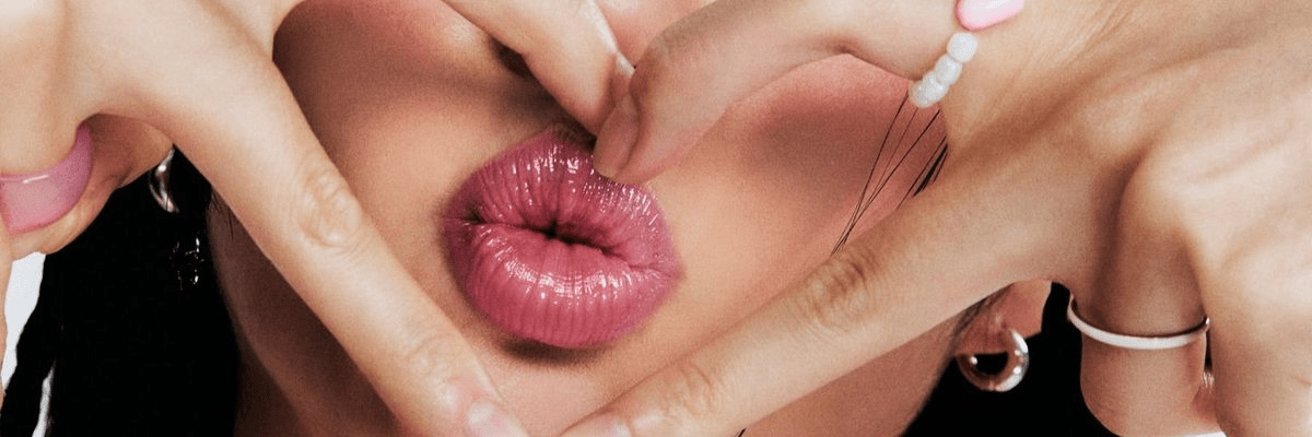 woman's lips pouting with a gen z finger heart around them