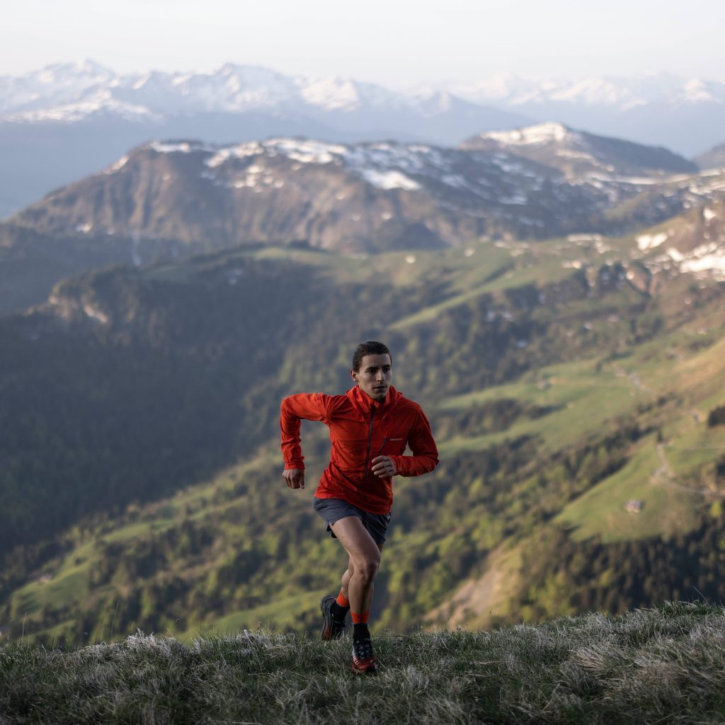 woman running up hill wearing merrell jacket