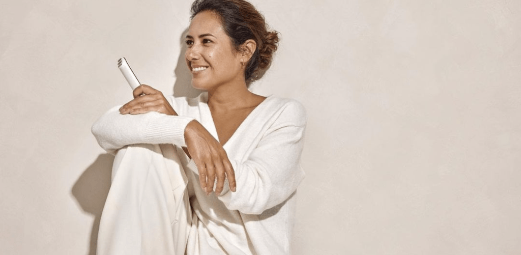 model sitting down smiling with silkn in hand