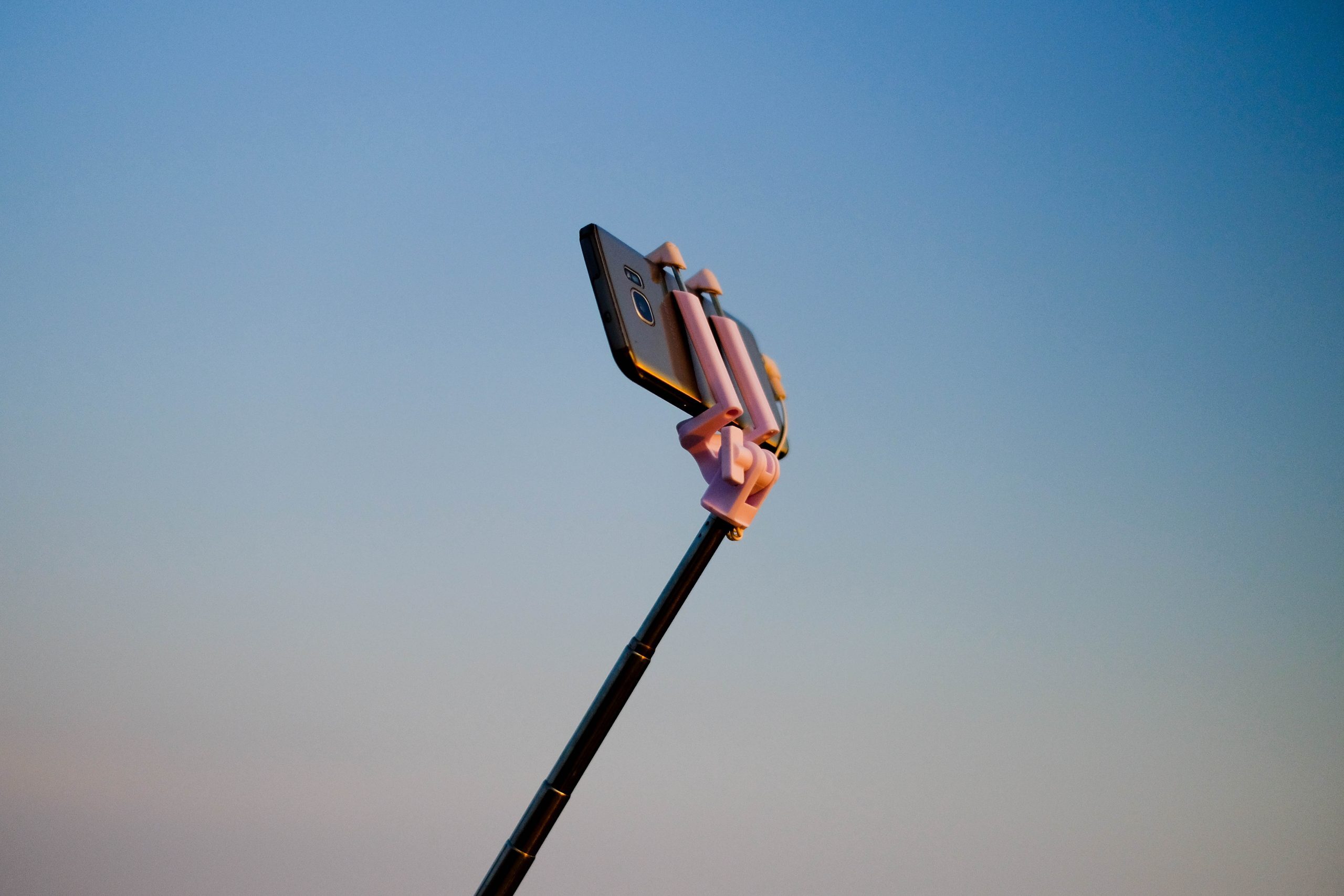 iphone on selfie stick from unsplash