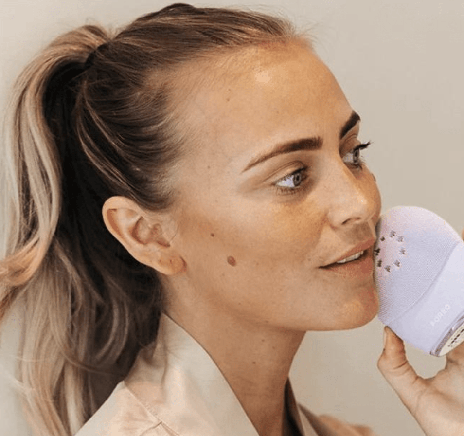 model using purple foreo on their cheek