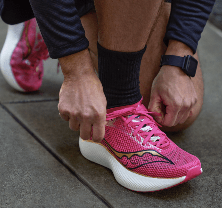 man putting on pink saucony endorphin trainers