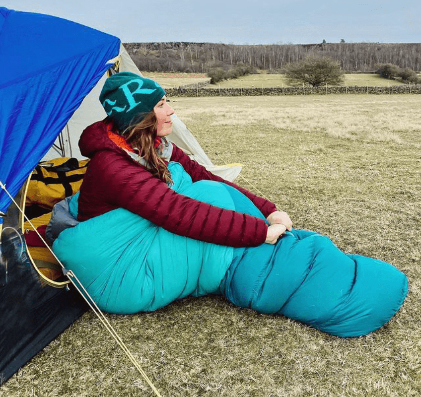 woman lying down outside tent in rab sleeping bag