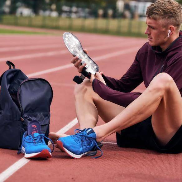 man taking out nurvv sole from trainer on running track